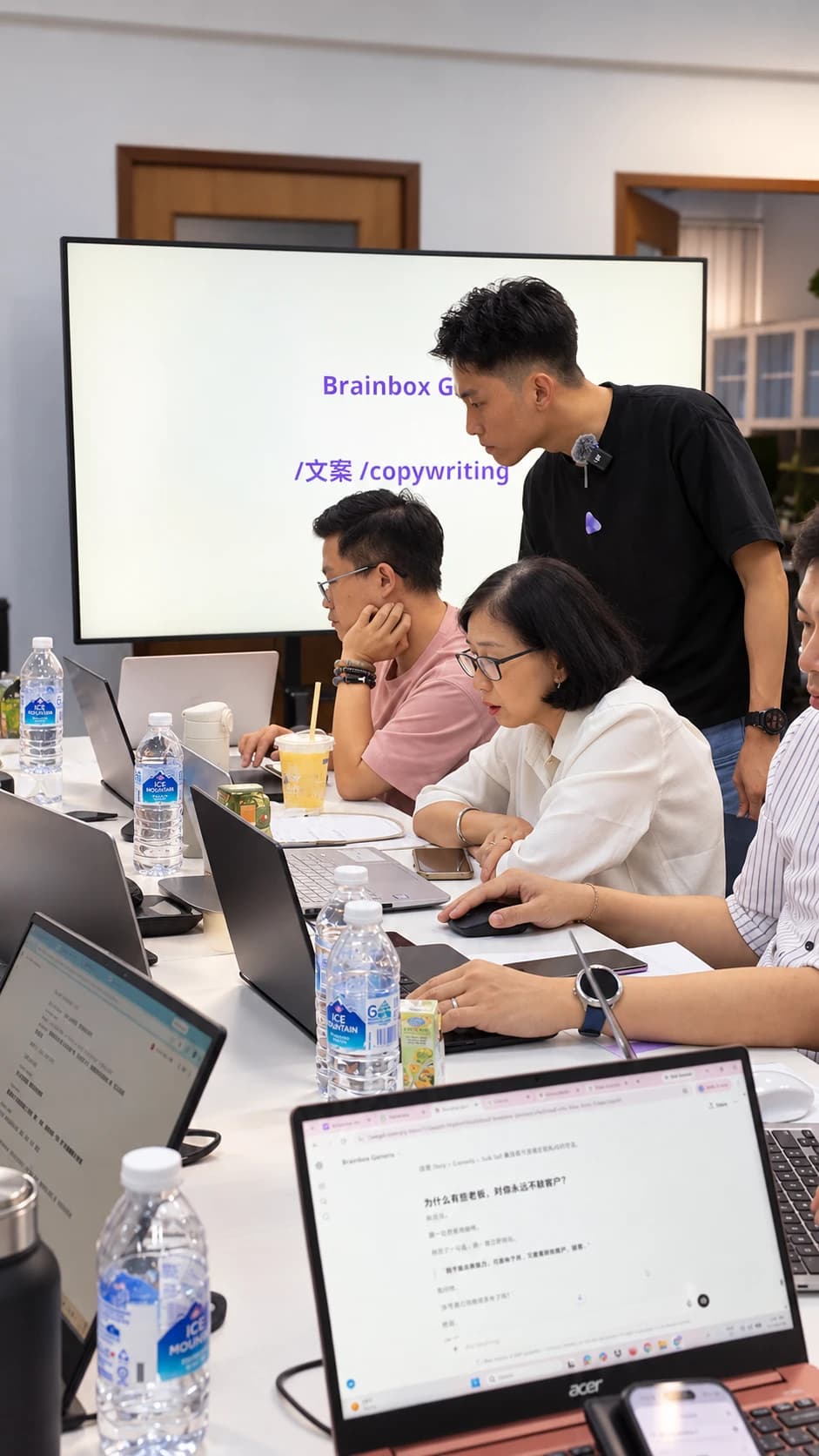 The mentor leaning in to help a student at a laptop